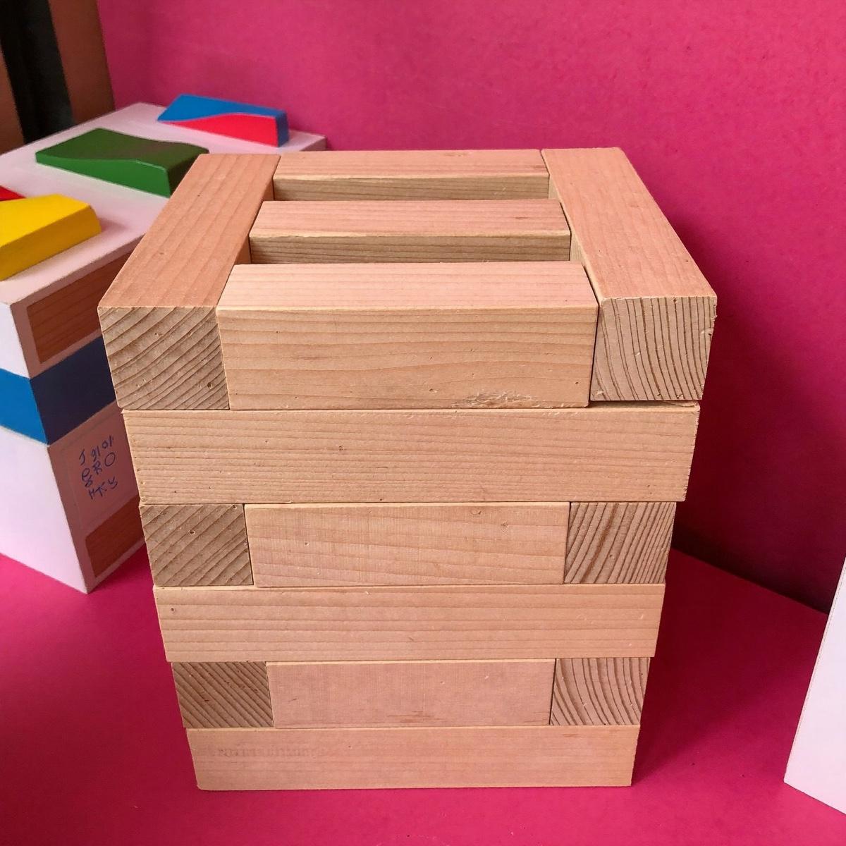 A small stack of plain wooden building blocks.
